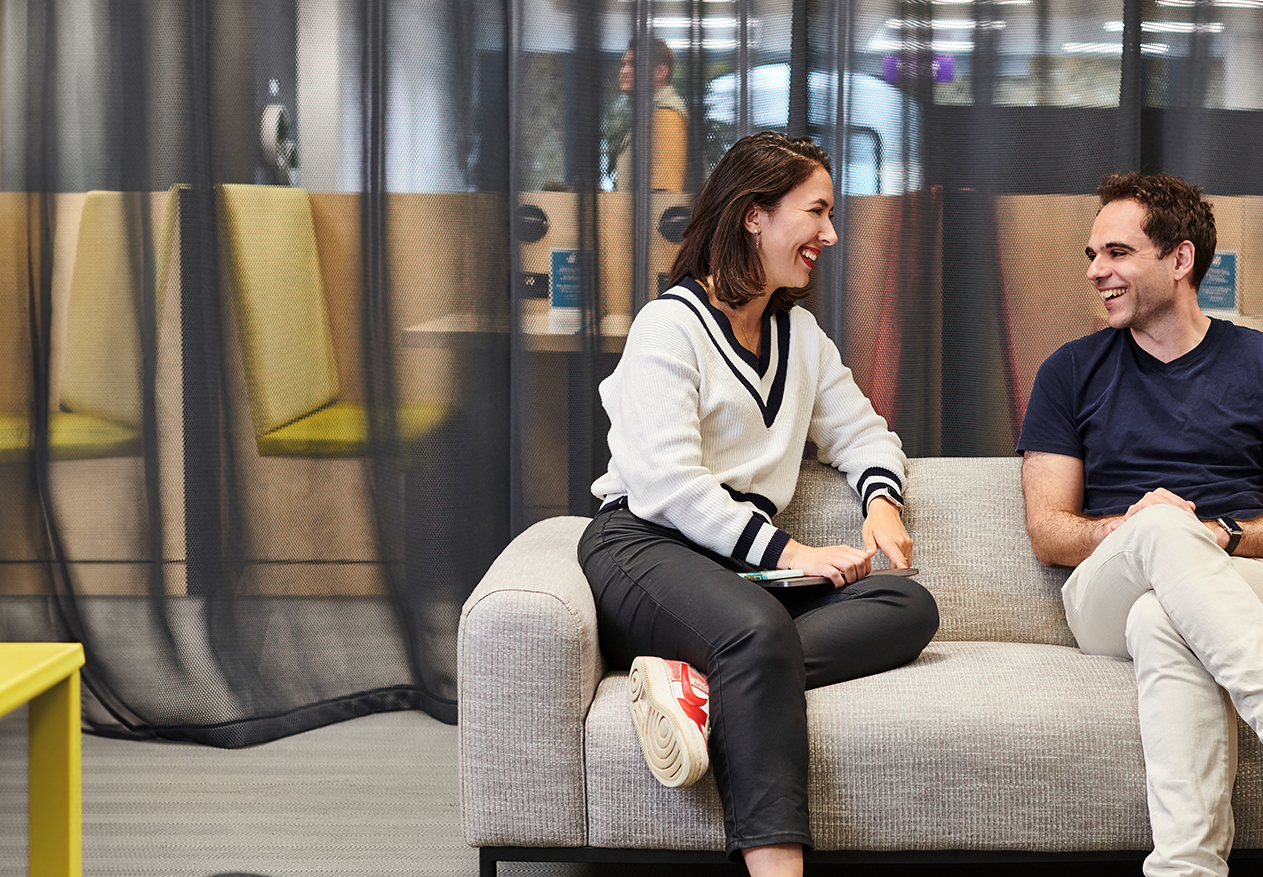 Two employees sitting down talking