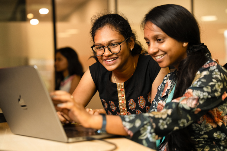 Two young women working at a laptop