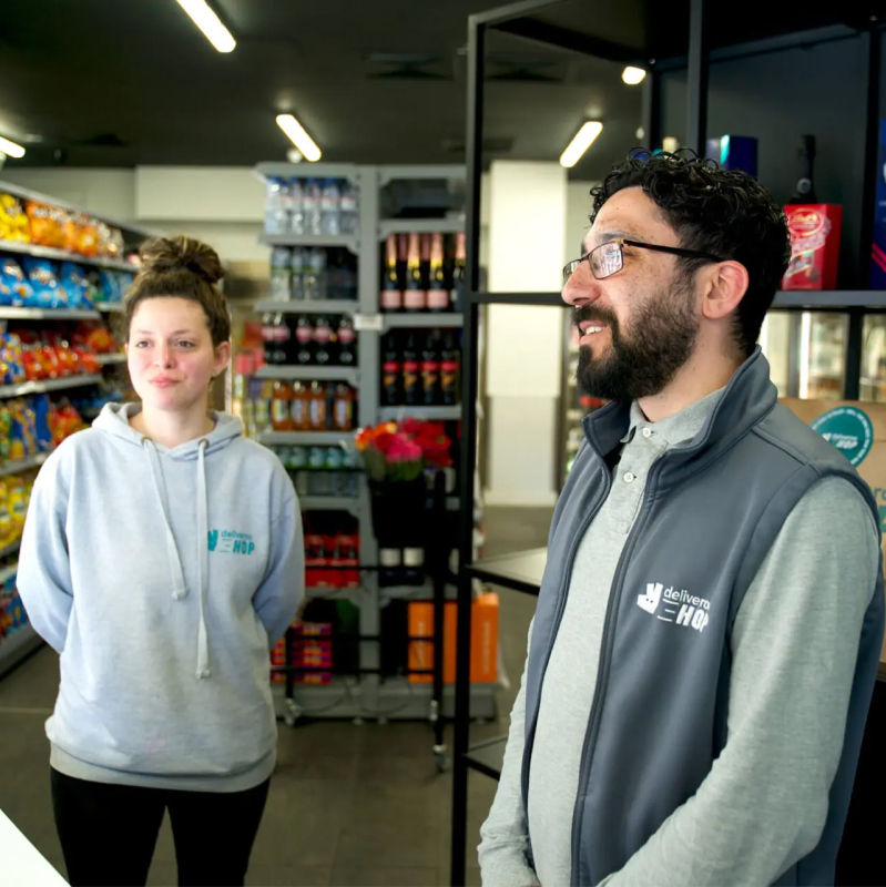 Two Deliveroo employees standing in a Deliveroo warehouse
